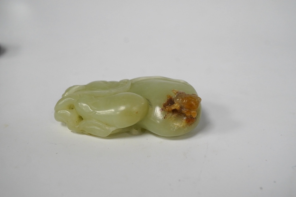 A Chinese pale green jade gourd pendant, a Chinese jade white and russet jade figure of a recumbent goat and a Chinese hardstone recumbent figure of an ox, largest 6cm wide (3)., Condition - good